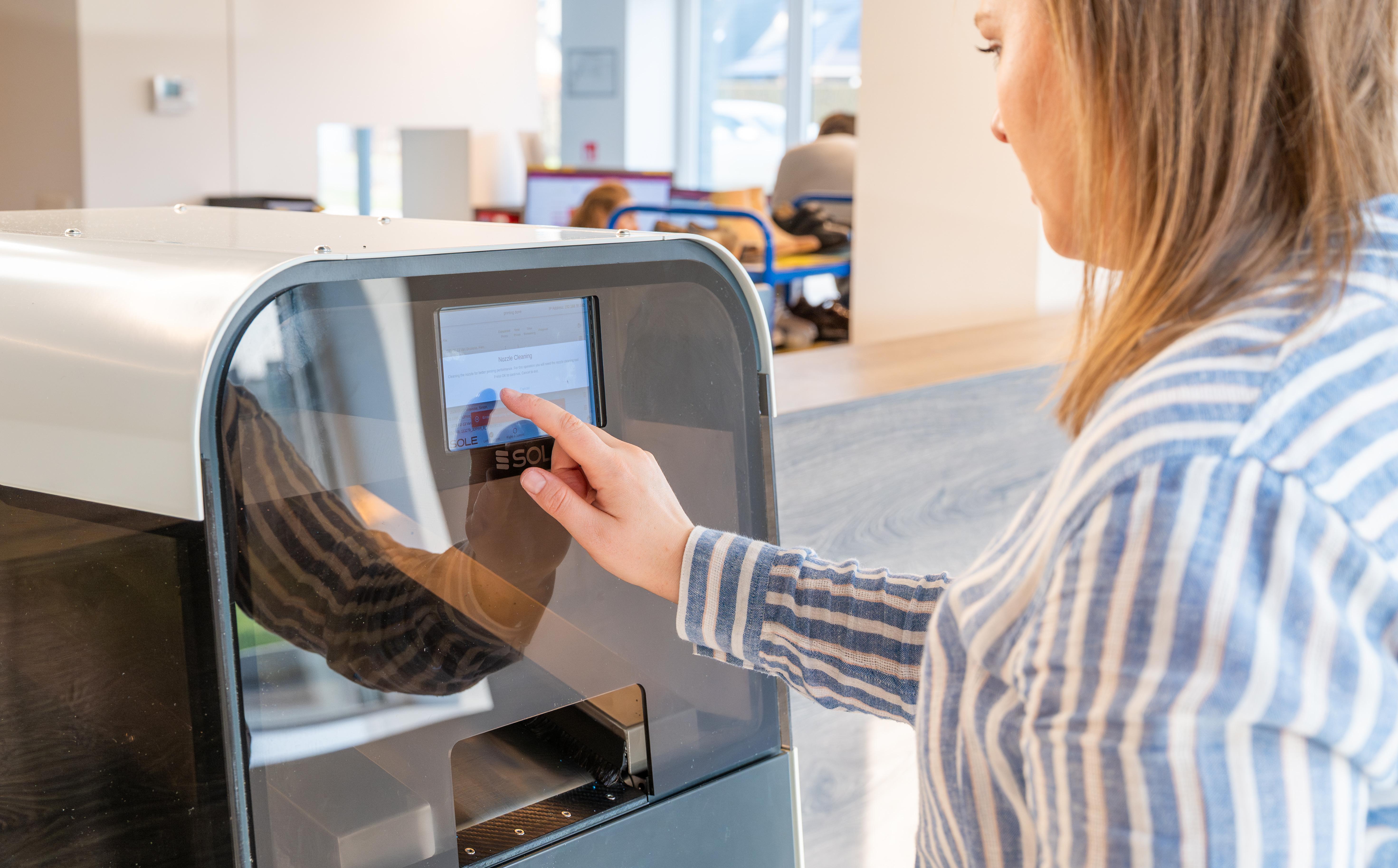 Spécialiste utilisant l\'écran tactile de notre scanner 3D de pointe pour la modélisation de semelles et chaussures.